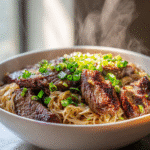 Garlic butter steak lightning noodles in a white bowl